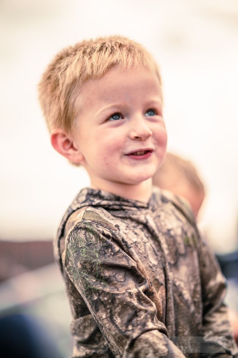 Young boy in a camo hoodie looking up