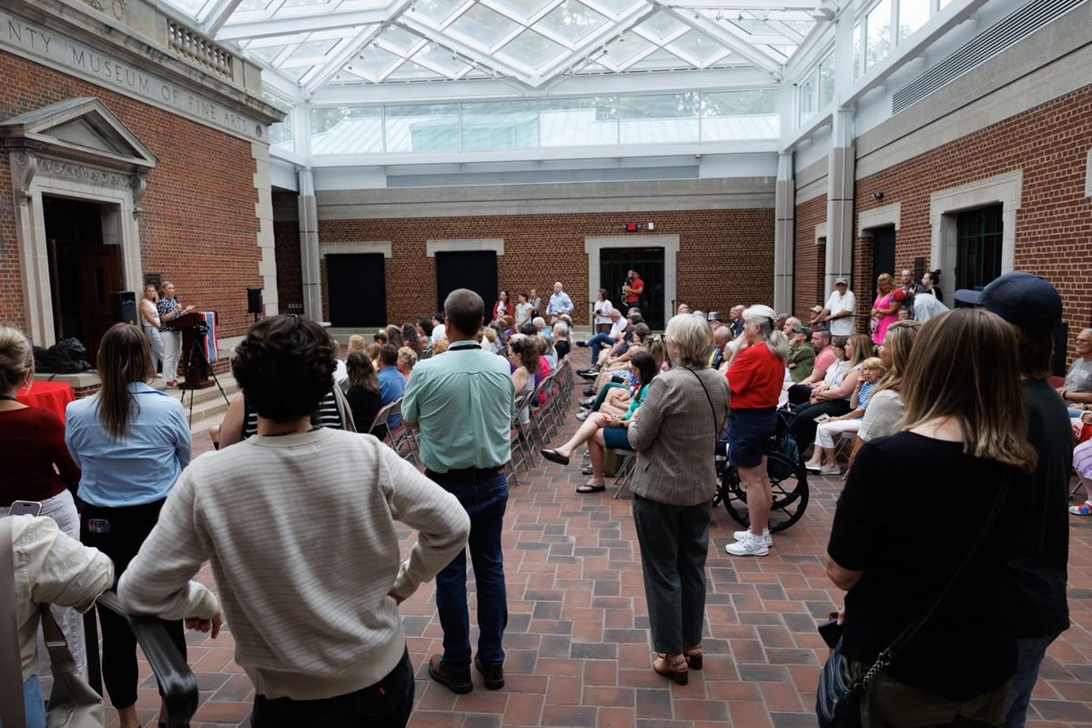 Crowd gathered in a museum atrium for an event